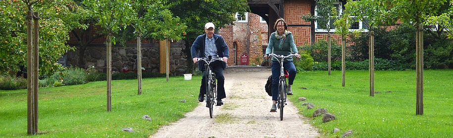 Patient with infantile paralysis polio poliomyelitis cycling with his wife. Due to back pain caused by incorrect posture when walking, he is treated with a custom-made knee-ankle-foot orthosis KAFO with an automatic joint.