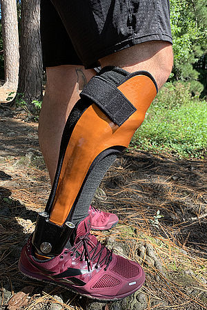 Adult with dynamic orthosis that gives security when standing and walking in the field x-cross through pre compressed spring units waterproof and protection against dirt and grime
